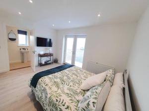 a bedroom with a bed and a couch and a television at Sea Breeze - Sea Scape View in Keiss