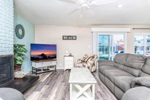 a living room with a couch and a tv at Cozy Family Beach Home Half Block To Popular 44Th St Beach By Beachview Rentals in Newport Beach