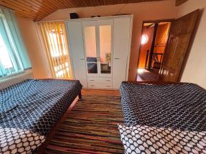 a room with two beds and a hallway with a door at La Grumpy in Văleni
