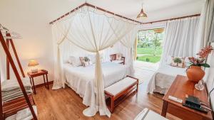 a bedroom with a bed with a canopy at Pousada Recanto Caxando in Trancoso