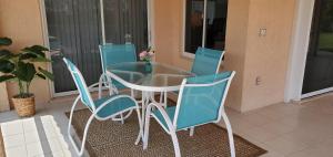 a glass table and four chairs on a patio at Citrus Breeze in Clermont