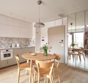 a kitchen and dining room with a wooden table and chairs at Luxury Art Apartment Wrocław in Wrocław