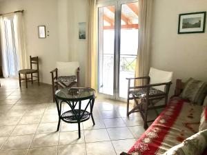 a living room with a glass table and chairs at Under the pine tree in Divarata