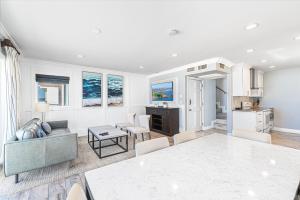 a living room with a couch and a table at Modern 3Br Oceanfront W Rooftop Deck & Panoramic Views By Beachview Rentals in Newport Beach