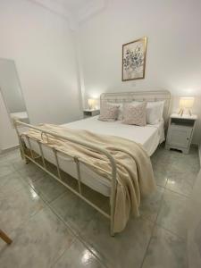 a bedroom with a large white bed with pillows at Eraora Lofts & Appartments Kefalonia in Lakithra