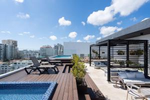 a rooftop deck with chairs and a swimming pool at 9+Ocho Suites by Yellowkey in Santo Domingo