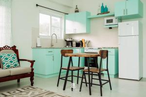a kitchen with blue cabinets and a table and chairs at Ocean Mist Suites in Arnos Vale