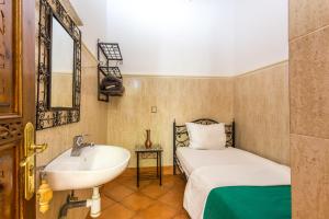 Un baño con lavabo y cama. en Hotel Atlas, en Marrakech 24 fotos más
