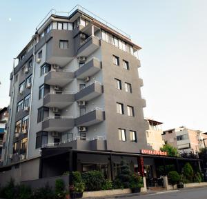 a tall gray building with balconies on a street at Hotel Riviera in Durrës +42 photos
