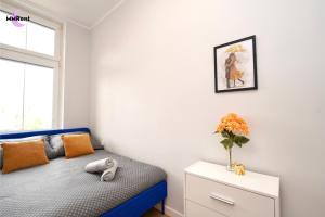 - une chambre avec un lit bleu et un vase de fleurs dans l'établissement MMRent Umbrella Room, à Gdańsk