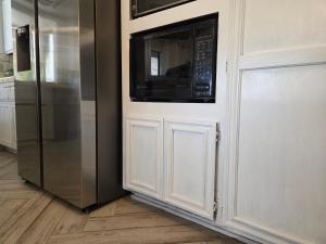a kitchen with a refrigerator and a microwave at Chic Lake House 3 bedroom in Helendale