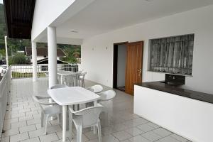 a white kitchen with a white table and chairs at Large apartment in the center in Pomerode