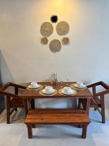 drewniany stół z płytami i kieliszkami do wina w obiekcie Tulum Jungle loft with Pool and rooftop near Beach and Cenotes and dowtown! Fast WiFi! Perfect for Expats w mieście Tulum