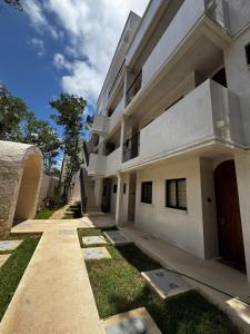 duży biały budynek z chodnikiem i trawą w obiekcie Tulum Jungle loft with Pool and rooftop near Beach and Cenotes and dowtown! Fast WiFi! Perfect for Expats w mieście Tulum +31 zdjęć