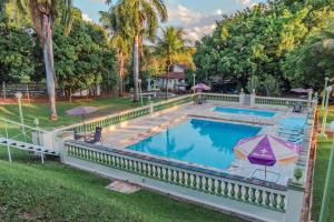 an image of a swimming pool with umbrellas at Hotel Estancia Santa Amélia in Jabuticabal