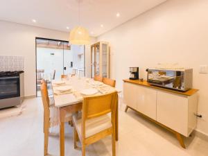 eine Küche und ein Esszimmer mit Tisch und Stühlen in der Unterkunft Casas Aconchegantes a 600m da Praia de Paúba in São Sebastião