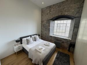 a bedroom with a bed and a brick wall at 5 Brewhouse by Pureserviced in Plymouth