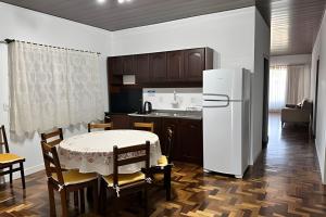 a kitchen with a table and a white refrigerator at Apartment well located in the center in Pomerode