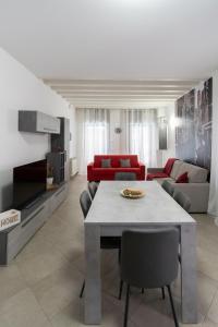 un soggiorno con un tavolo e un divano rosso di El raposso a Chioggia