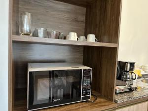 a microwave on a shelf in a kitchen at Apartment in the Center in Pomerode