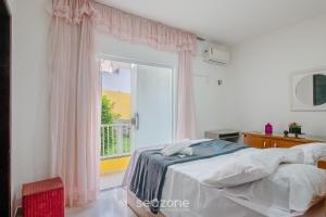 a bedroom with a bed and a large window at Estadia com piscina a 250m do mar no Stella Maris, Salvador - DIA in Salvador