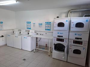 a laundry room with washing machines and a sink at Concord Pilar Suite Almendros in Pilar