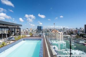 a swimming pool on top of a building with a city at 9+Ocho Suites by Yellowkey in Santo Domingo