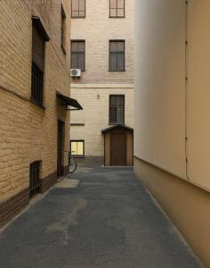an alley between two brick buildings with a garage at Vecrīgas dzīvoklis in Riga