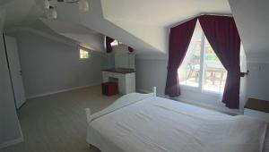 a bedroom with a white bed and a window at Oludeniz Villa with Private Pool in Fethiye