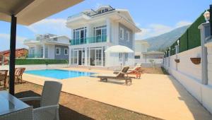 a large house with a swimming pool in front of it at Oludeniz Villa with Private Pool in Fethiye
