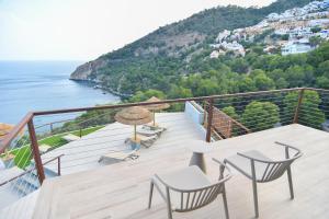 Un balcón con mesa y sillas y el mar. en Hotel Hyalma Cliff - Adults Only, en La Herradura