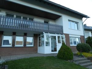 a house with a balcony on top of it at FeWo Ruhe in Olsberg