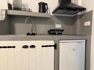 a kitchen with white cabinets and a sink at Urban Tinos in Tinos