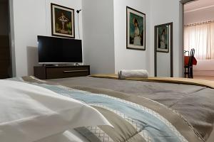 a bedroom with a bed and a flat screen tv at Apartamento no Centro 2 in Pomerode
