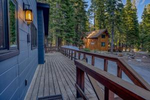 a wooden walkway leading to a cabin in the woods at Laid-Back Tahoe Stay Walk to Lake & EV Charger in Homewood