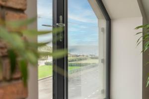 a sliding glass door with a view of a road at 37 West Portrush Luxury Penthouse in Portrush