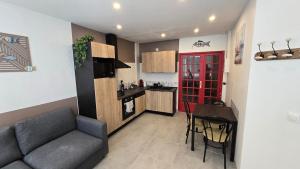 a kitchen and a living room with a couch and a table at Le treport - centre - Plain-pied 1 chambre in Le Tréport +3 photos