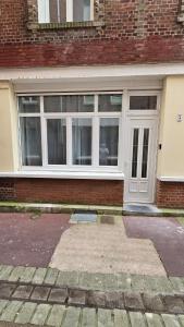 a front door of a brick building with a window at Le treport - centre - Plain-pied 1 chambre in Le Tréport