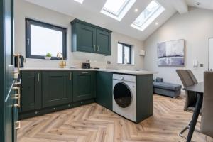 a kitchen with green cabinets and a dishwasher at Beachside Escape Luxury apt - Portrush in Portrush