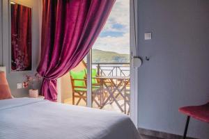 a bedroom with a bed and a view of a balcony at Studios Diogenis in Porto Koufo