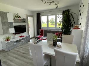 a living room with a table and chairs and a television at Haus im Grünen in Bad Zell
