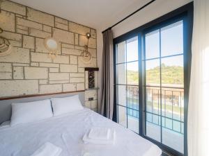 una camera da letto con un letto bianco e una grande finestra di Blanco a Çeşme Altre 53 foto
