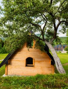 a small dog house in a field with a tree at Wolf's PEAK in Kolašin