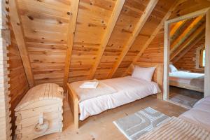 a bedroom in a wooden cabin with a bed at Wolf's PEAK in Kolašin