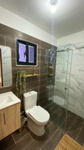 a bathroom with a toilet and a glass shower at Apt AT THE HEART OF DOWNTOWN-PUNTA CANA WHERE LUXURY MEETS COMFORT in Punta Cana