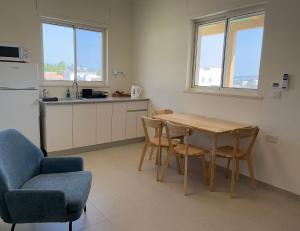 a kitchen with a table and chairs and a kitchen with a refrigerator at פינה למרגלות הגלבוע in Bet Alfa