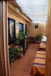 a room with two beds and a flat screen tv at Hostal Buenaventura in Valdivia