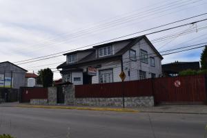 una casa al lado de una calle con una valla en Hostal Buenaventura, en Valdivia