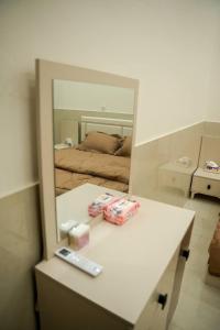 een spiegel die een kamer met een bed en een tafel weerspiegelt bij شقق قلب العاصمة in Bagdad