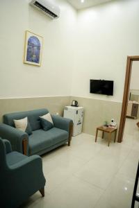 een woonkamer met een bank en een tv bij شقق قلب العاصمة in Bagdad +3 foto's